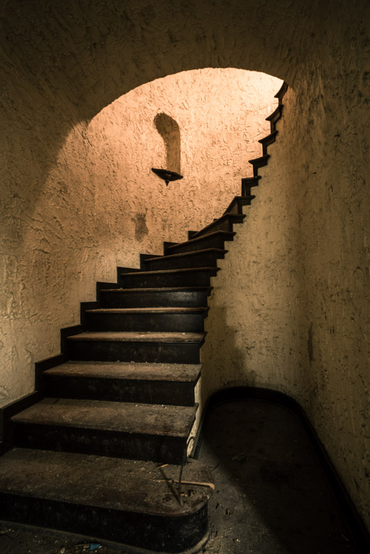 abandoned stucco home curved stairwell