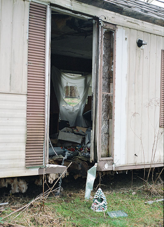Abandoned mobile home at Lily of the Valley Campground, Thompson, Ohio, with a broken entrance, cluttered interior, and